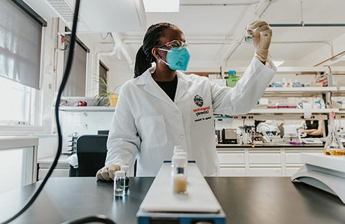 person holding a vial up to inspect